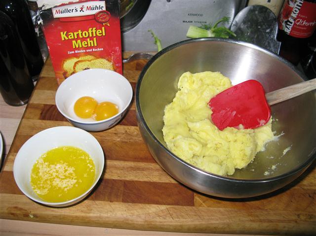 Unter den Kartoffelteig werden erst die zwei Eigelb untergearbeitet. Dann die Butter und anschließend das Kartoffelmehl, gewürzt wird der Teig mit Salz und einem Hauch Muskatnuss.