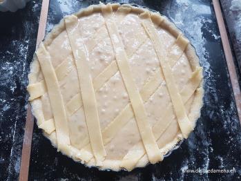 Streifen zuschneiden und über den fertigen Kuchen ein Gitter (Rauten) formen. Die Teigstreifen dienen dazu, dass die Creme während des Backens nicht über den Rand rinnt.