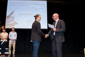 Cornelius Oesterlee (mitte), Studiengangsleiter. Rico Schultis (l.) erhält von Dr.