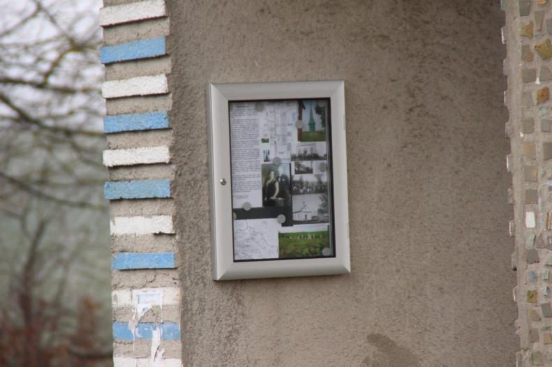 Eine Gedenktafel für Bronislawówka, angebracht in einem Schaukasten an einer Bushaltestelle im