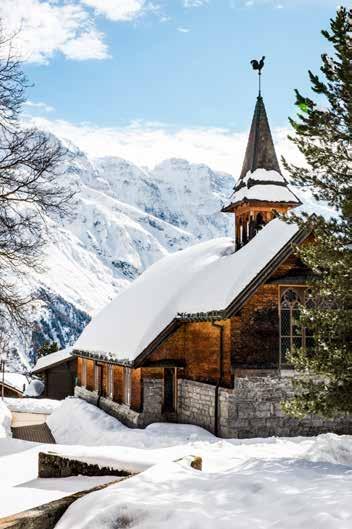 Globetrotterin mit starken Wurzeln in der Jungfrau-Region: Audrey Ramponi und ihr Hund Mila. Braun gegerbte Holzfassaden wie jene der reformierten Kirche bestimmen das Dorfbild von Mürren.