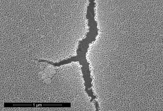 Right: SEM image of the same layer where a local delamination of the top titania layer uncovered a second TiO 2 nanotube layer below.