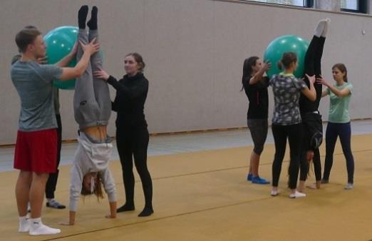 Die Beine werden nacheinander gestreckt und mit Schwung Richtung Gymnastikball gebracht. Benutzt das Vorwissen aus den vorherigen Übungen, um die Spannung im Handstand zu halten." 5 Abb.