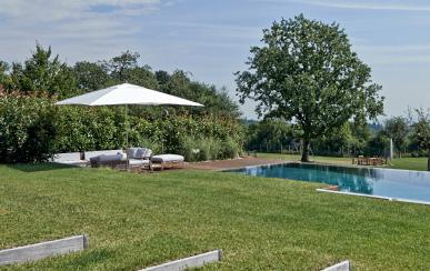 1 Der Garten ist terrassenförmig in mehreren Ebenen angelegt. Der Pool erstreckt sich mit einer breiten Infinity-Rinne unmittelbar in die weitläufige Gartenanlage.