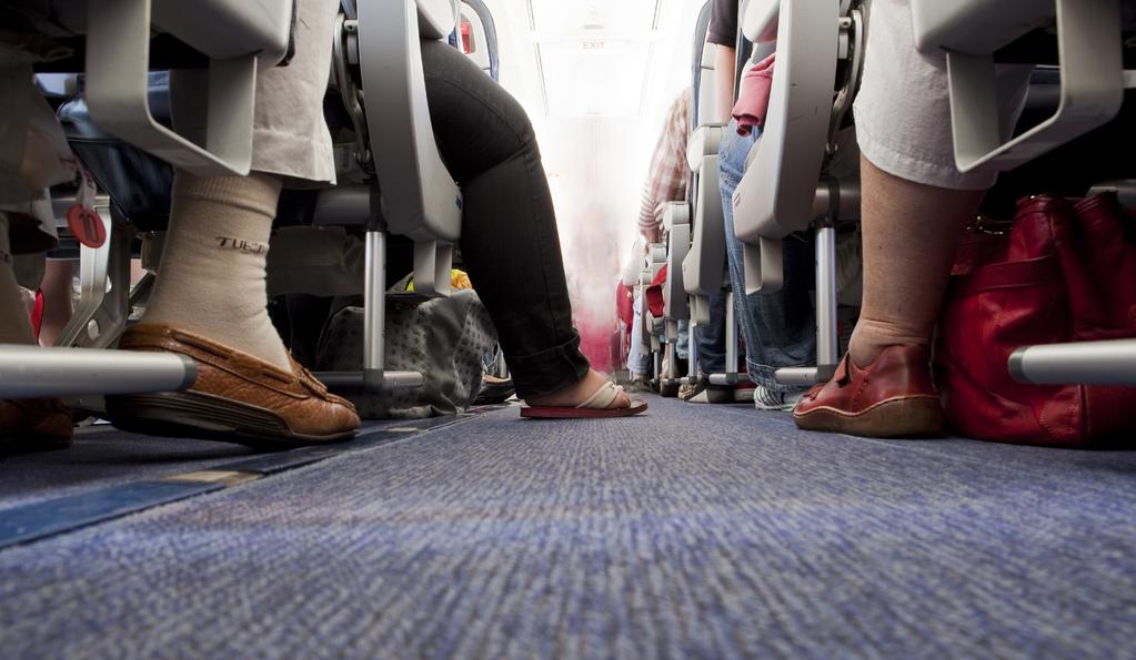 Belastungen bei Langstreckenflügen auf Auslandsdienstreisen Fernflüge in der Economy Class führen besonders bei großen Menschen zu einer Zwangshaltung. dar.