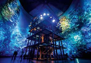 Dabei werden künstlerisch verdichtet die unterschiedlichsten Formen des 2000 Kilometer langen Ökosystems unter Wasser in einem Riesenrundgemälde gezeigt.