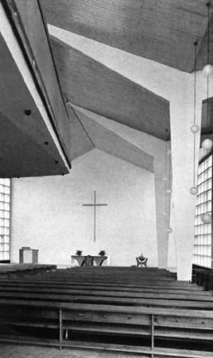 die Stufen einbezogen, rechts steht das Taufbecken. Die Altarzone wird seitlich von raumhohen Betonmaßwerkfenstern nach dem Muster der Fassade belichtet.