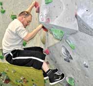 Bouldern heißt: Klettern ohne Seil und Gurt. Sechs Beschäftigte gehen jede Woche mit den Sport-Lehrern in die Kletter-Halle. Sie können schon richtig gut klettern und haben viel Spaß dabei.