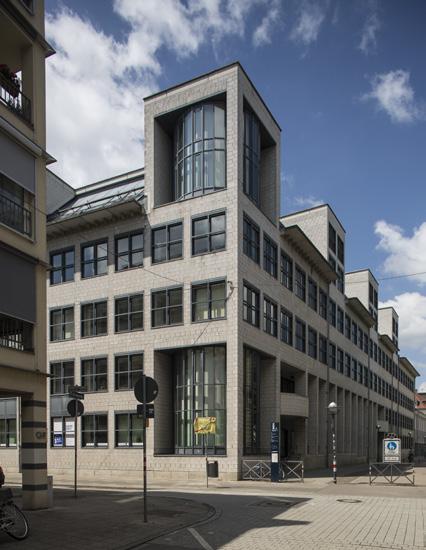 Architekten Heinz Mohl. Das dreigeschossige Gebäude ist mit hellen Betonsteinen verkleidet und besitzt eine klar ge gliederte Lochfassade mit quadratischen Fenstern.