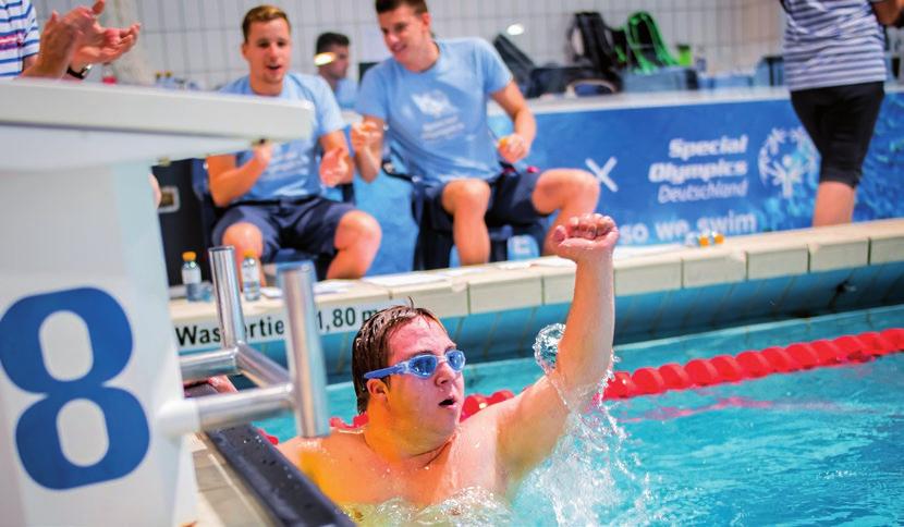 Athlet Marco Küpfer freut sich über seinen Erfolg beim s.oliver Schwimmfest. Im Hintergrund die Kampfrichter Ruwen Straub und Sebastian Beck, Schwimmer beim SV Würzburg 05.