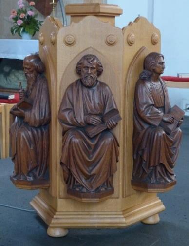 Vorne im Altarraum findest du an der Kanzel die Figuren von vier Männern. Schau sie dir mal an, was haben sie alle in den Händen? Das sind die 4 Evangelisten Markus, Lukas, Johannes und Matthäus.