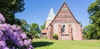 Sie besitzt mit ihren hohen Findlingsmauern und dem angebauten Naturstein-Rundturm aus dem 12.