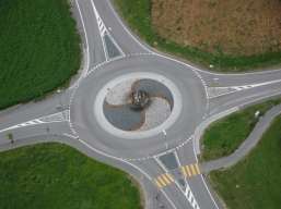 In einem Kreisverkehr haben die Fahrzeuge Vorfahrt, die im Kreisverkehr fahren. Deshalb steht an den Einfahrten in den Kreisverkehr ein Verkehrszeichen Vorfahrt gewähren.