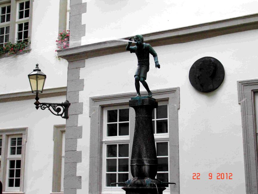 Junge auf dem Schängelbrunnen im Rathaushof.
