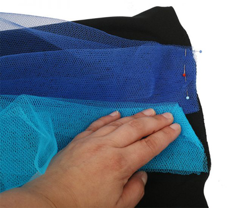 Dieses Bündel aus Tüllstreifen stecken Sie an die obere noch offenen Kante des Unterkleides.