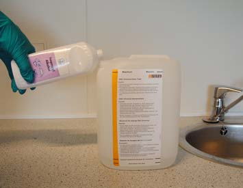 Füllen Sie den gereinigten Abwasserbehälter bis zur unteren Markierung auf dem Etikett mit Wasser. 7. Fügen Sie bis zur zweiten Markierung auf dem Etikett Isopropanol (Alkohol >70%) hinzu.