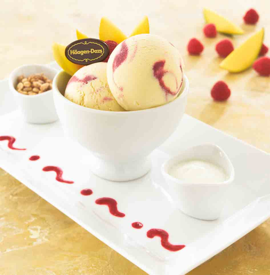 MANGO & RASPBERRY FRUIT FUSION Zwei Scoops Mango & Raspberry Eiscreme garniert mit Mango-Stückchen und