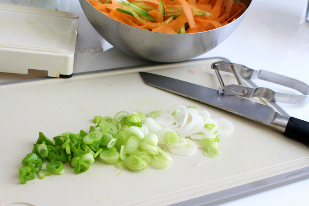 4. Die Gurke mit dem Gemüsehobel bzw. dem Messer in feine längliche Streifen schneiden. 5. Karotten mit dem Gemüseschäler in breite Streifen hobeln. 6. Den Koriander fein hacken. 7.
