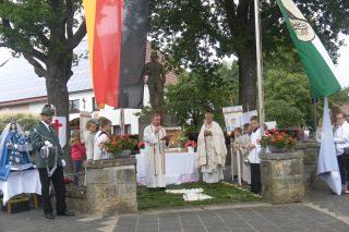 Merlsheim. Traditionsgemäß wird früh am Morgen vor der Messe ein Blumenteppich vor der Kirche gelegt.