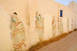 In einer Straße ist beispielsweise eine verschleierte Frau mit einer Eisenmaske vor dem Gesicht großflächig an die Wand gemalt.