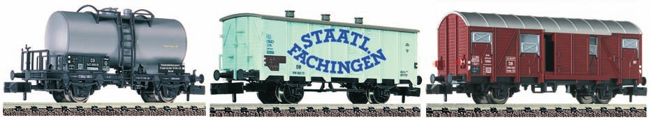 25-56 und 4 Güterwagen, wobei ein Wagen mit Kohle beladen ist, 1 Fahrregler und 1 Steckernetzteil, 7 gerade Gleise (3 x 9100, 3 x 9101, 1 gerades