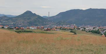 Косовска Митровица oder Kosovska Mitrovica aus der Ferne mit dem stolzen 300m hohen Bleischmelz-Kamin Mitrovica (Ausgesprochen Kosofska Mitrowitza ) ist der ehemalige jugoslawische und serbische Name