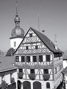 Durch das Tor gelangt man zum Marktplatz und dem prächtigen Rathaus mit reichem Fachwerkschmuck (Bild links).