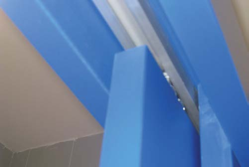 Befestigung an der Wand mittels U -Profil die Tür ist in Schiebetürbeschläge mit oberer Führungsschiene eingehängt, Ansichtsfläche der Pressspan-Türplatte in derselben Farbe wie die Trennwände im