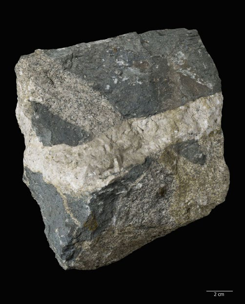 Diese Minerale konzentrieren sich am kühleren basalen Rand des Sills. (Wärmeretention führt zur Bildung gröberer Kristallisate bei mächtigeren Sills).