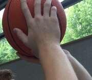 Über Kopfhöhe wird die linke Wurfhand unter den Ball gebracht, der Ellenbogen zeigt in Richtung Korb, wohingegen die rechte Hand als Stützhand seitlich am Ball fungiert. Abb.