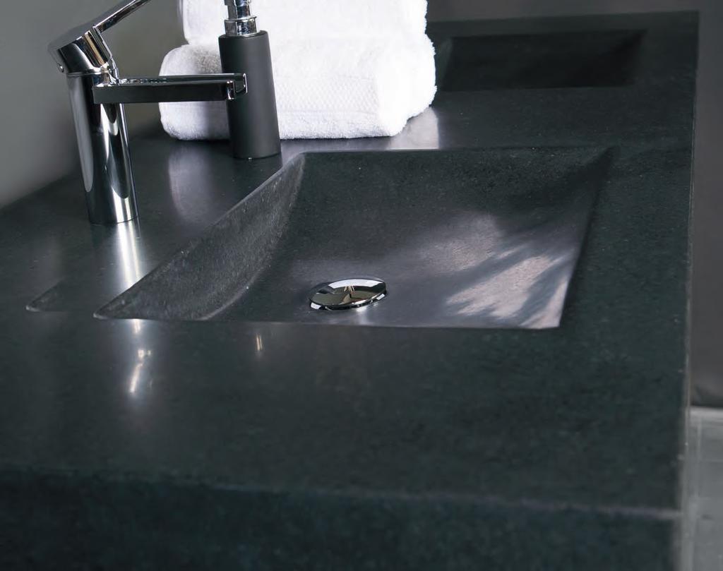 Een handgevormde wastafel uit één stuk natuursteen. In het design valt vooral de schuine afloop op.