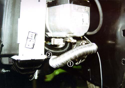 Halter (B), am rechten unteren Befestigungspunkt vom Gerätehalter Das flexible Abgasrohr von der HYDRONIC zum Abgasschalldämpfer verlegen