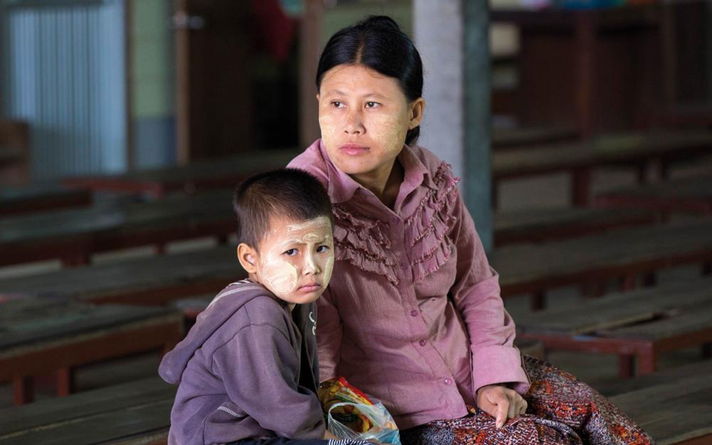 In der Wang Pha Klinik wartet eine burmesische Mutter mit ihrem Kind, das Symptome einer Malaria aufweist.