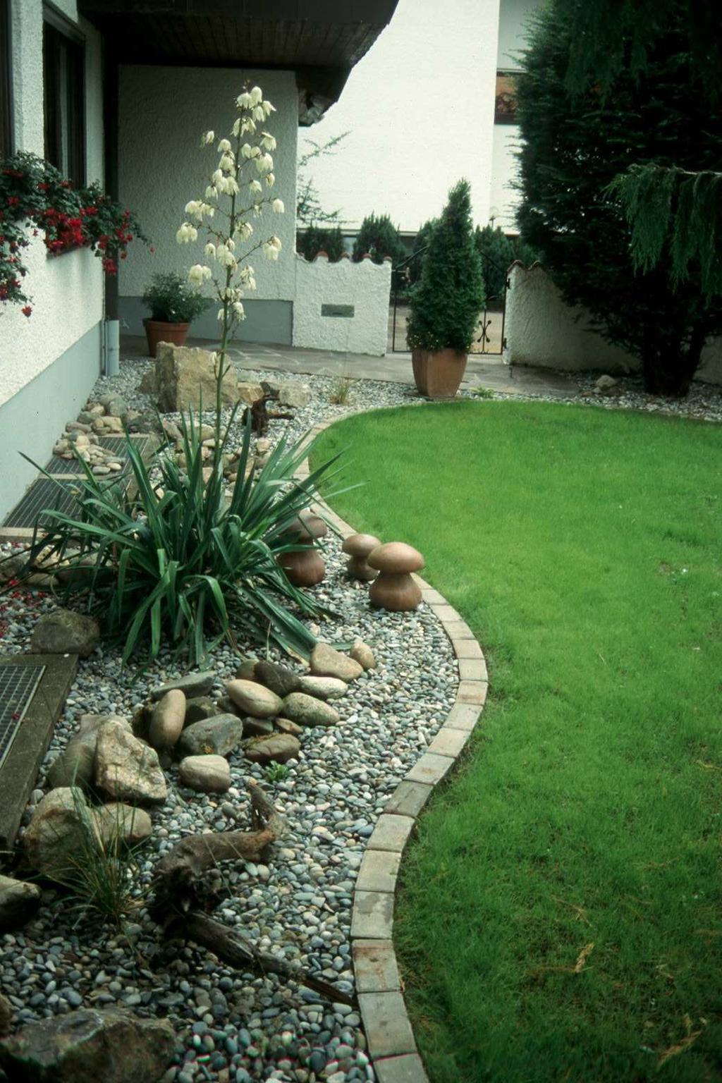 Ein langweiliger Kiesstreifen am Haus wird umgestaltet Es entsteht ein ansprechender, pflegeleichter Vorgarten entlang der Mauer