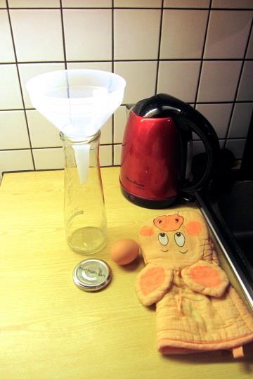 Forscherauftrag Nr. 3 Das Ei in der Flasche Lasse dir bei diesem Experiment von einem Erwachsenen helfen! 1 Saftflasche aus Glas mit großer Öffnung (ca. 3,5 cm) und mit Deckel 1 Ei etwas Fett (z.b. Butter) 1 Trichter kochendes Wasser Topflappen 1.