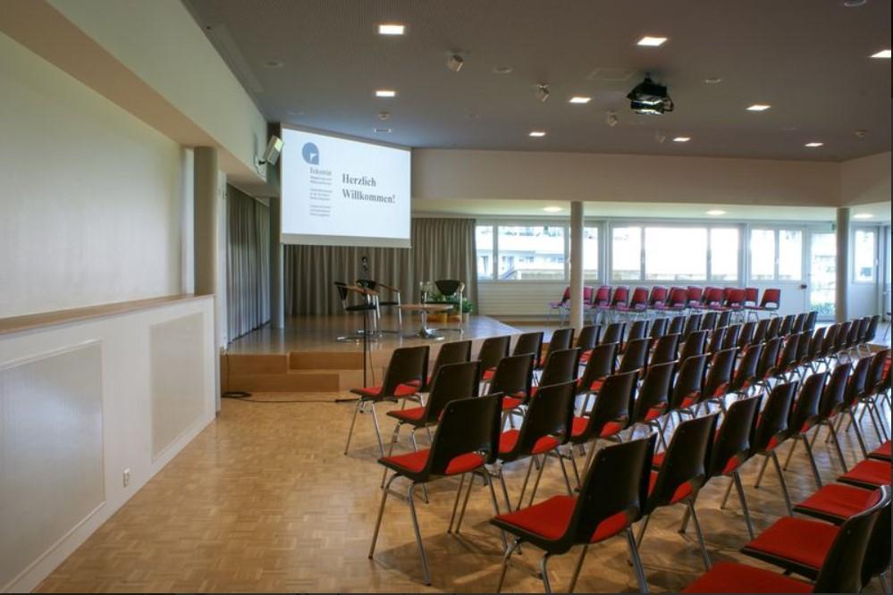 Saal A Unser Grosser: ausgerüstet mit Simultan-Dolmetschanlage, zwei Beamer/Leinwänden und fixer Bühne ist er für mehrsprachige Konferenzen und Vorträge bis zu 170 Personen bestens gerüstet.