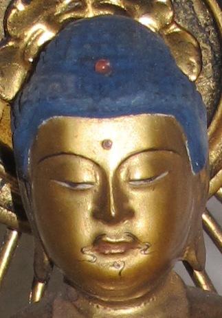 Wenn eine Buddhafigur eine Haarfarbe hat, ist sie immer blau. Dazu bietet hier das Grün des Lotus-Sockels einen frischem Kontrapunkt.