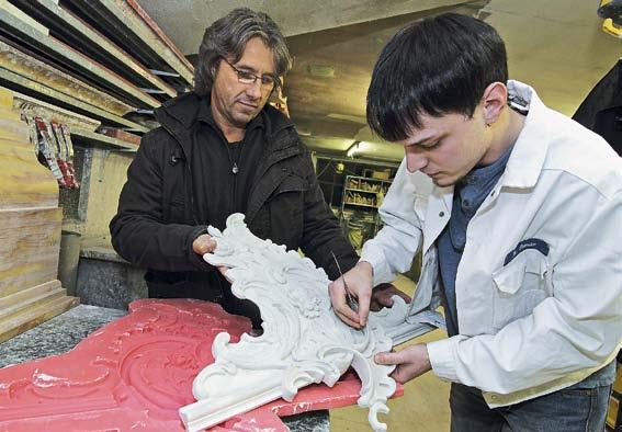 Ausbildung Stefan Michaelis bei der Arbeit an einem Werkstück aus Gips, sein ehemaliger Chef Marcus Klarhorst schaut zu.