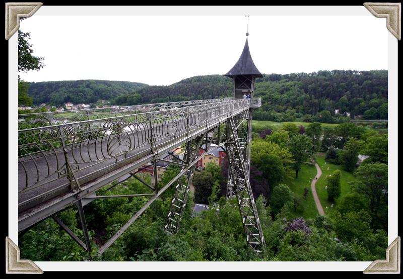 Der frei stehende 50 m hohe Stahlfachwerkturm wurde komplett im Jugendstil gestaltet. Oben verbindet eine Brücke den Turm mit einem Waldweg auf der Hochebene.