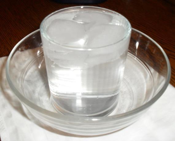 Stelle das Glas auf den Teller oder auf die Schüssel und gib bis zur Hälfte Eiswürfel hinein. 2.
