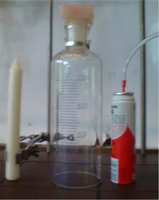 Versuchsaufbau: Abb. 1: Kerze, Gaszylinder, Dose mit Feuerzeuggas. Versuchsdurchführung: Eine stabförmige Kerze wird entzündet. Anschließend befüllt man einen 100 ml Stand- bzw.