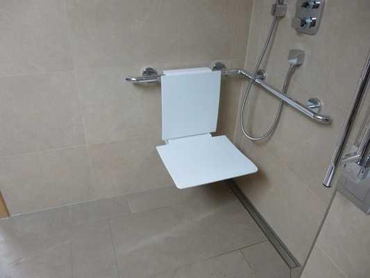 Es ist ein Duschsitz vorhanden oder kann bei Bedarf bereitgestellt werden (fest installiert, klappbar, einhängbar oder mobil und stabil). Es sind keine Haltegriffe in der Dusche vorhanden.