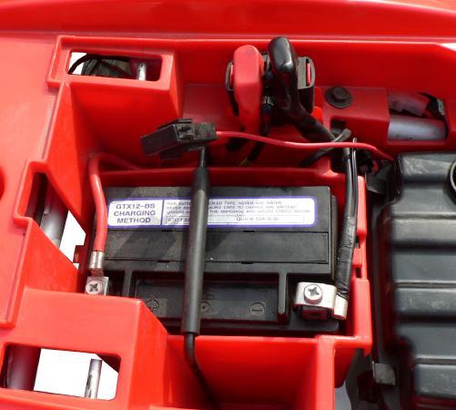 Batterie Prüfung Sie finden Sie die Batterie unter der Sitzbank des Fahrzeugs. Es handelt sich um eine wartungsfreie AGM Batterie. Das Auffüllen von destilliertem Wasser ist nicht notwendig/möglich.