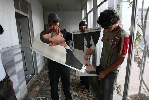 Syrische Rebellen zerreißen am 22. Juli 2012 ein Portrait des syrischen Präsidenten Bashar al-assad.