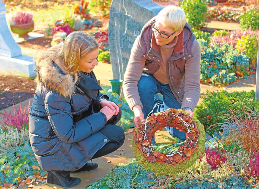 Foto: BdF, Bonn Besinnliche Stimmung Individuelle Farbtupfer auf den Gräbern wirken tröstend Tanne, Konifere und Grabschmuck, der bis zum Frühjahr halten kann, geschmückt.