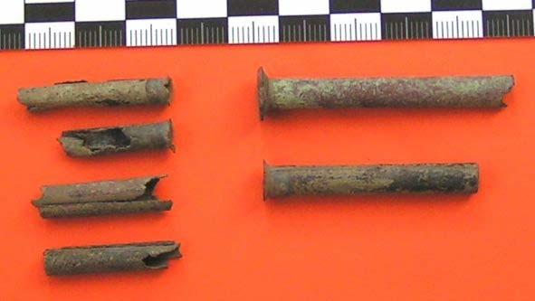 links: verschiedene benutzte Kanonenzünderbruchstücke, rechts oben: ein SH Zündröhrchen rechts