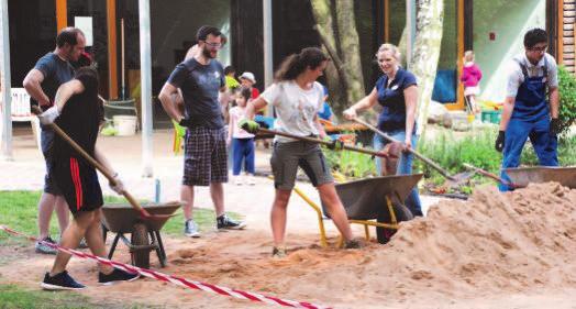 Der neue Sand musste per Hand in den kleineren Sandkasten des Kindergartens geschaufelt werden.