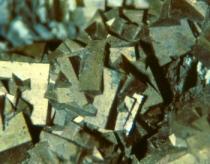 An der Oberfläche derartiger nieriger und traubiger Massen erscheinen schuppige, normalerweise kleine rhomboedrische Kristalle. Größere Individuen weisen leichte Krümmung der Kristallflächen auf.