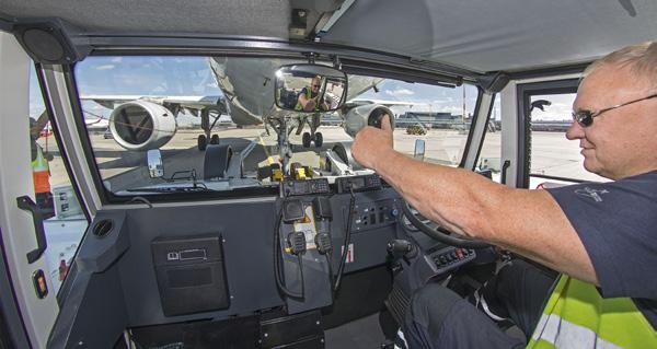 Mit geübter Hand steuert Viktor Fink, seit über 20 Jahren am Airport beschäftigt, das niedrige, schwere Fahrzeug auf das Flugzeug zu. Zwei gelbe Greifarme umfassen die beiden Reifen am Bug.