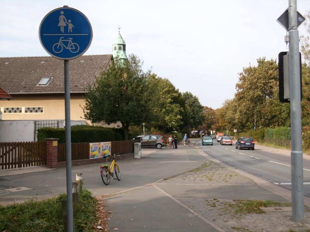 Ab hier, bis zum Kreisel, Fußgänger und Fahrradfahrer in beiden Richtungen zusammen auf einer Straßenseite, vor dem Kiosk